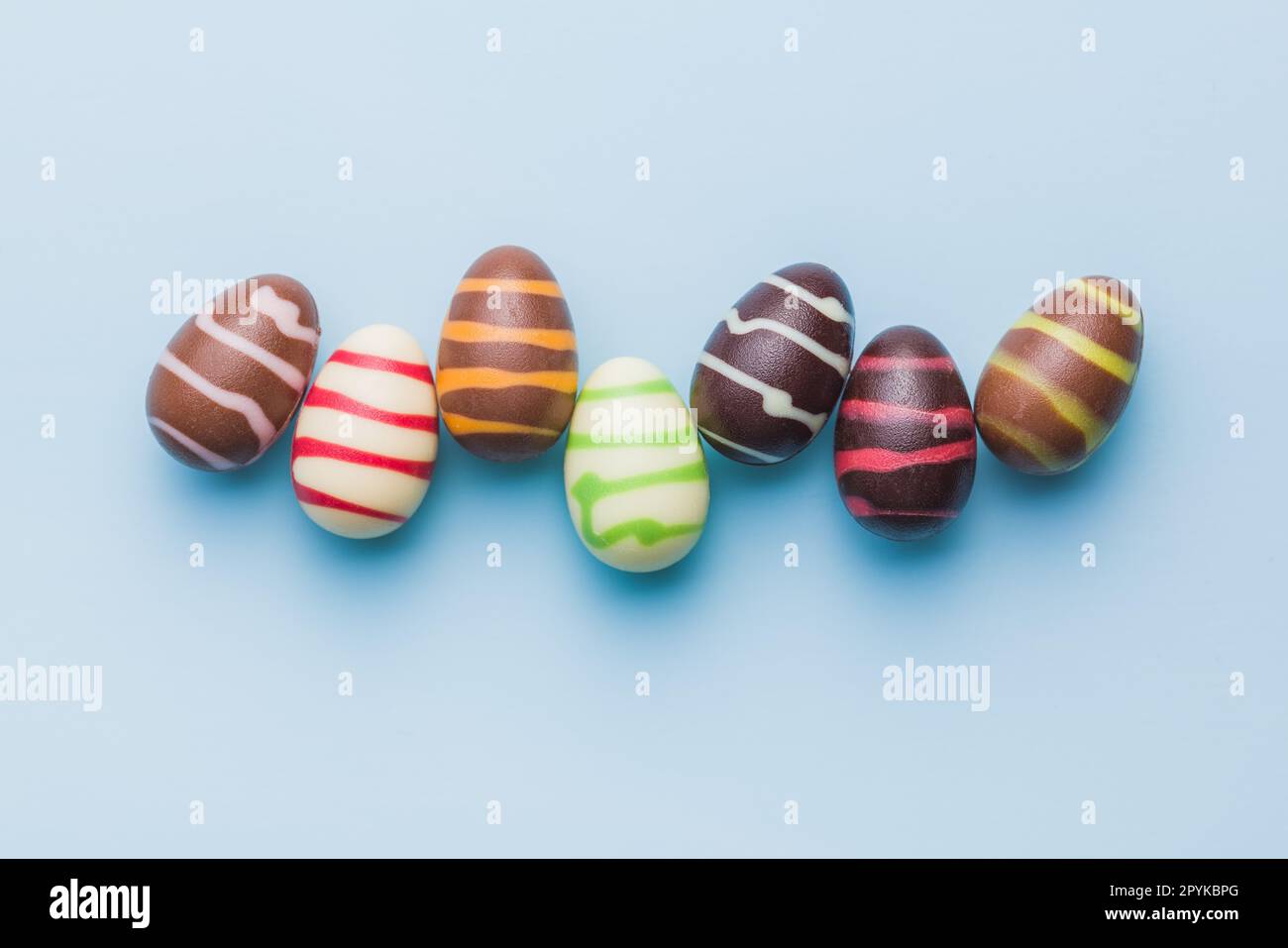 Chocolate easter eggs on blue background. Top view. Stock Photo