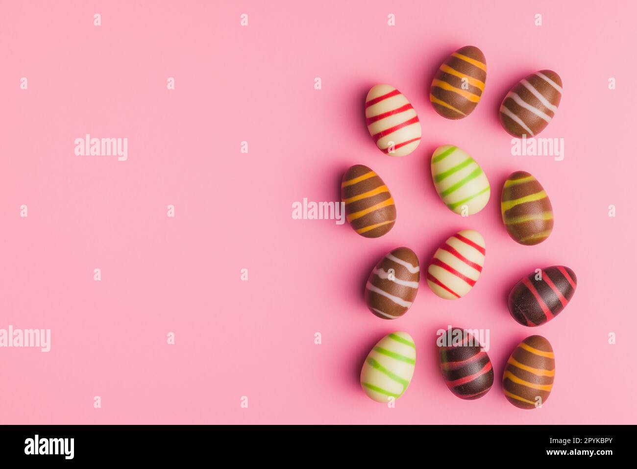 Chocolate easter eggs on pink background. Top view. Stock Photo