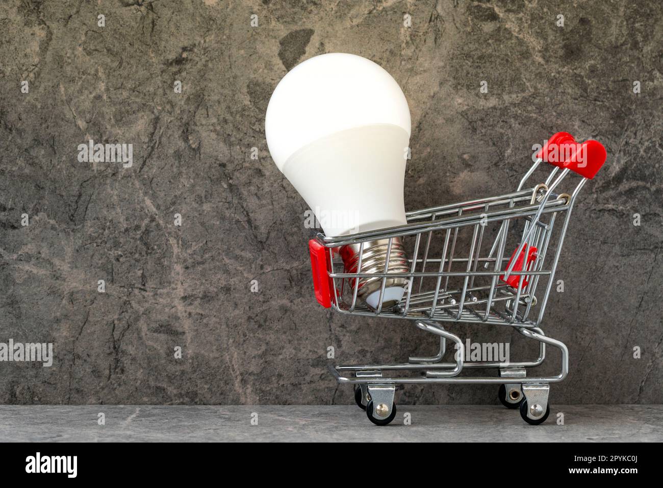 Shopping cart with bright glowing light bulb Stock Photo