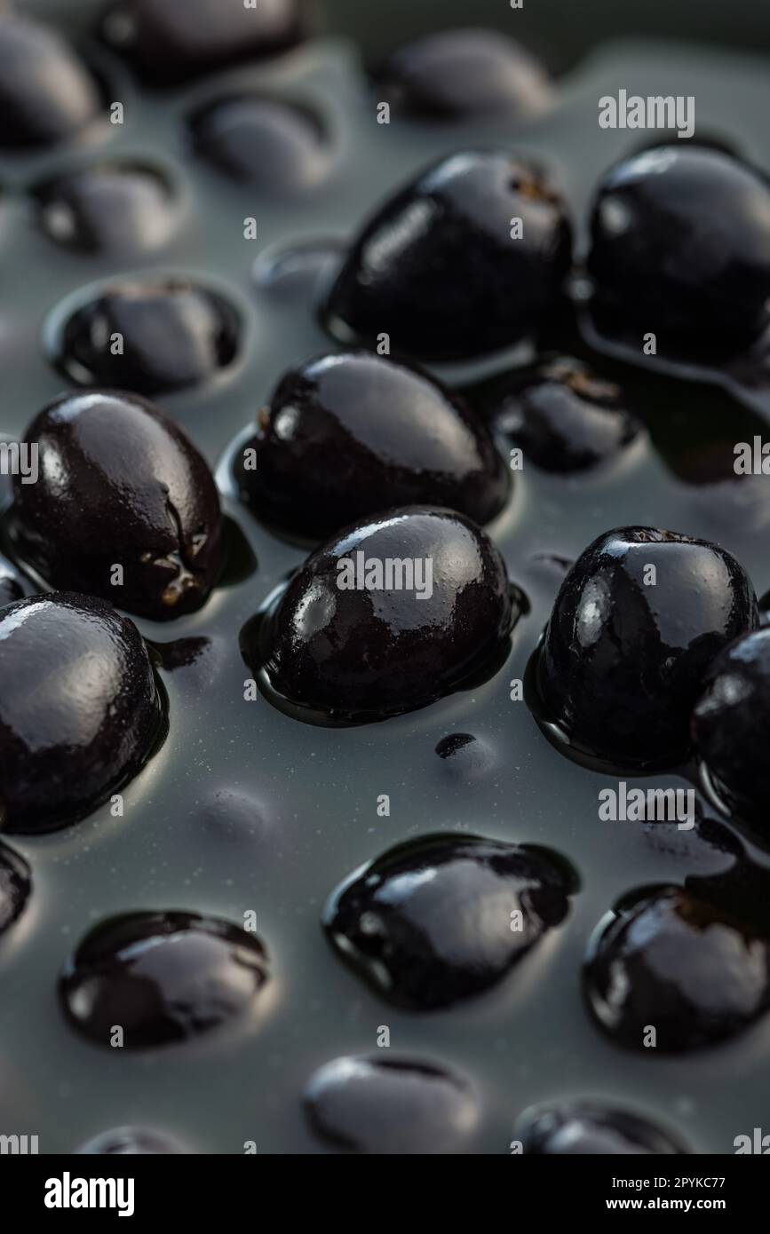 Pitted black olives. Marinated olives in the pickle. Stock Photo