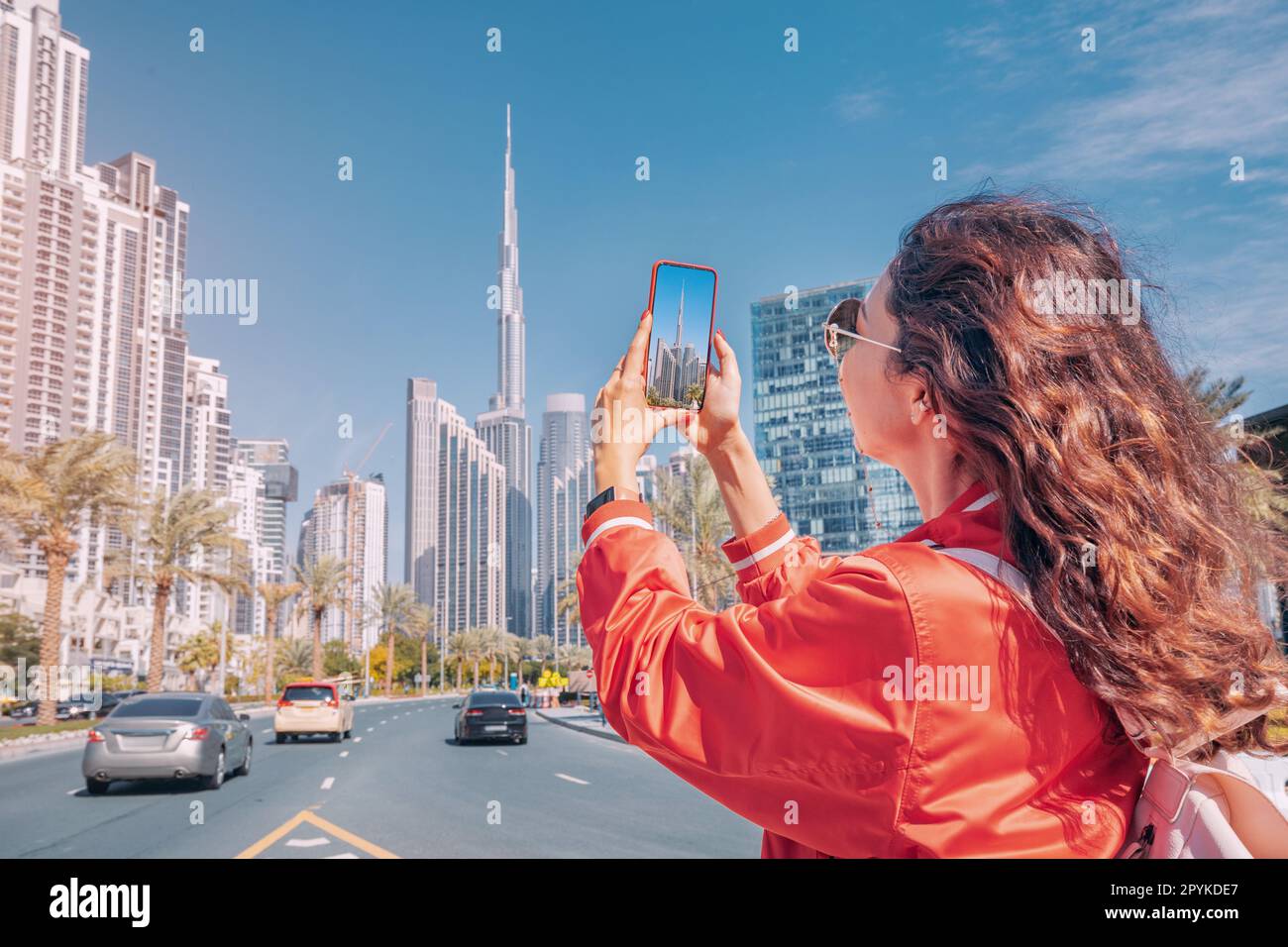 Tourist happy girl taking photos for her travel blog, in Dubai downtown