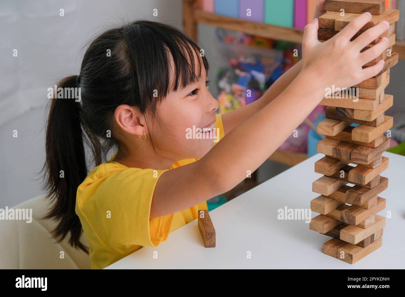 Cute Asian siblings having fun playing Jenga together. Two children ...