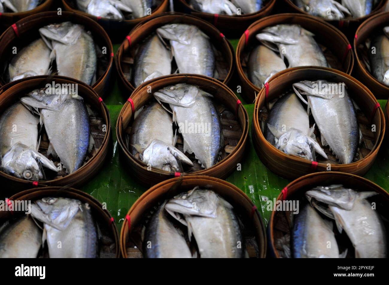 Steamed Thai Mackerel fish from Gulf of Thailand in bamboo basket for sale at the Mae Klong Railway Market Southwest  of Bangkok, Thailand. Stock Photo