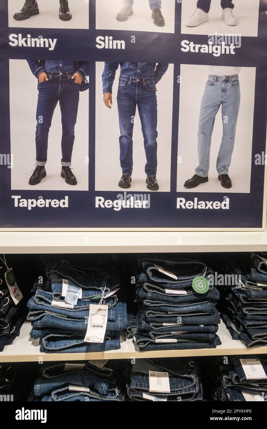 Denim jeans store display for men: tapered, regular, relaxed, skinny, slim, straight cut. Stock Photo