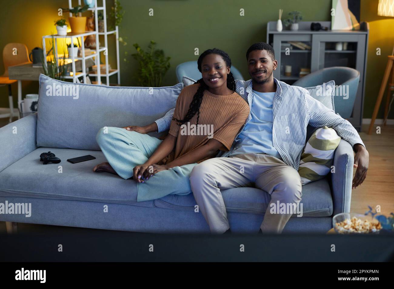 Happy African American couple sitting on sofa in the living room and ...