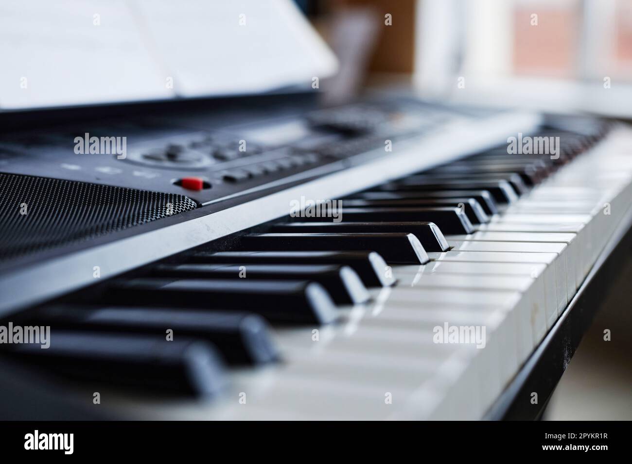 Closeup of synthesizer with sheet music for playing music in class