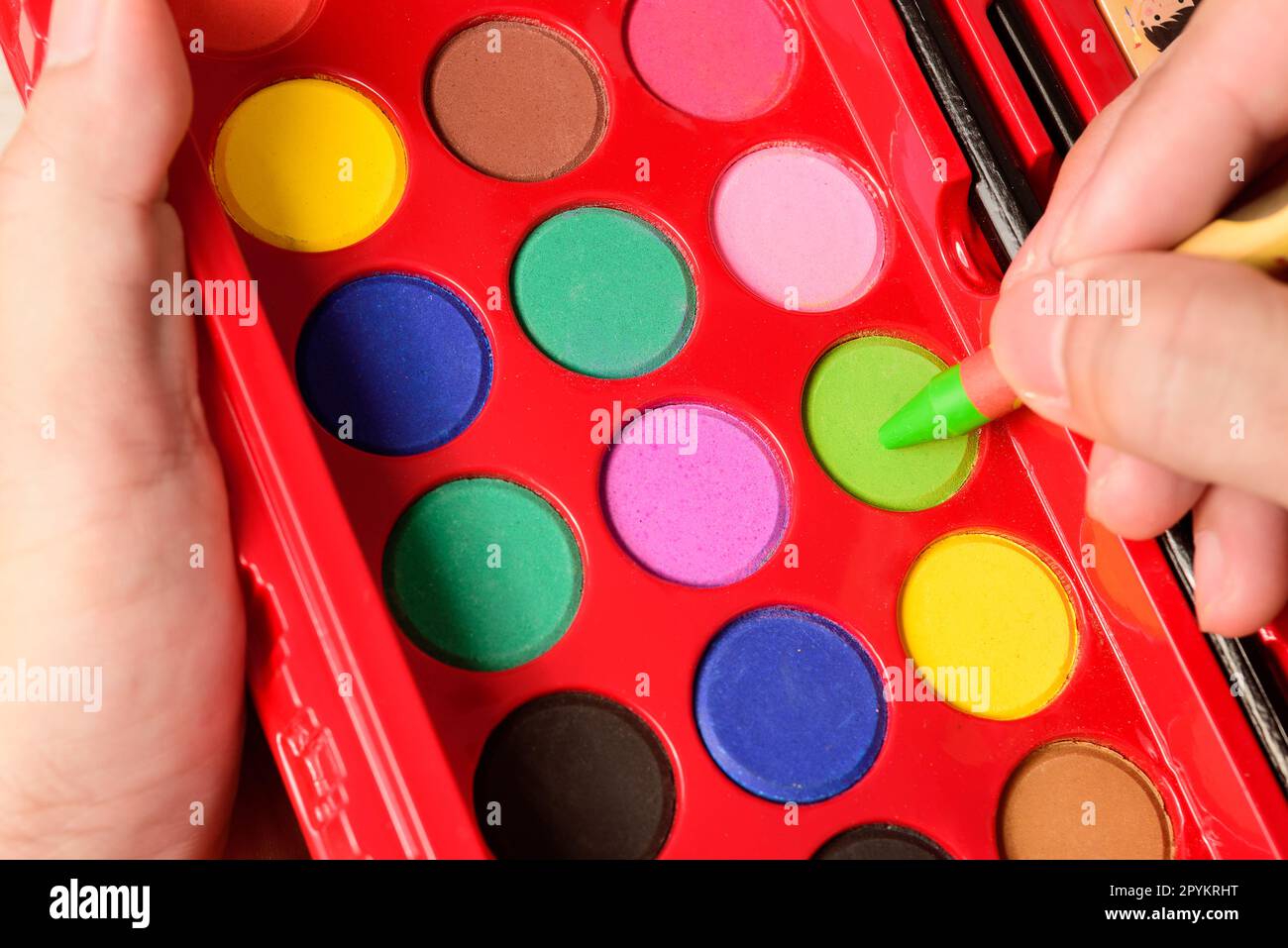 Set of watercolors in the box on hand. Palette of water color paints