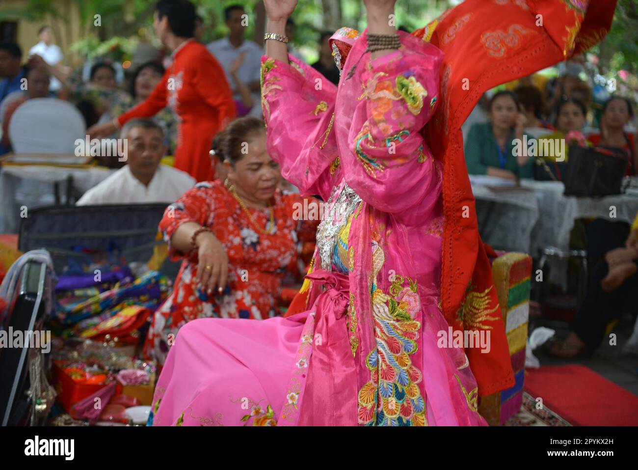 Shaman plays the role of a god performing rituals to transmit messages in Mother Goddess Worship event. Vietnam. Asia. hầu đồng. 越南旅游, 베트남 관광, ベトナム観光 Stock Photo