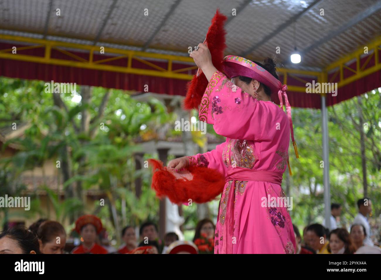 Shaman plays the role of a god performing rituals to transmit messages in Mother Goddess Worship event. Vietnam. Asia. hầu đồng. 越南旅游, 베트남 관광, ベトナム観光 Stock Photo