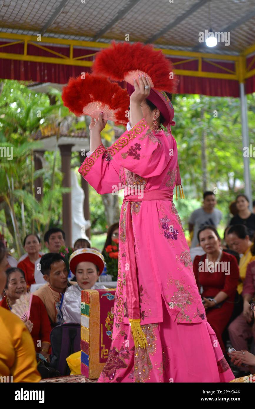 Shaman plays the role of a god performing rituals to transmit messages in Mother Goddess Worship event. Vietnam. Asia. hầu đồng. 越南旅游, 베트남 관광, ベトナム観光 Stock Photo