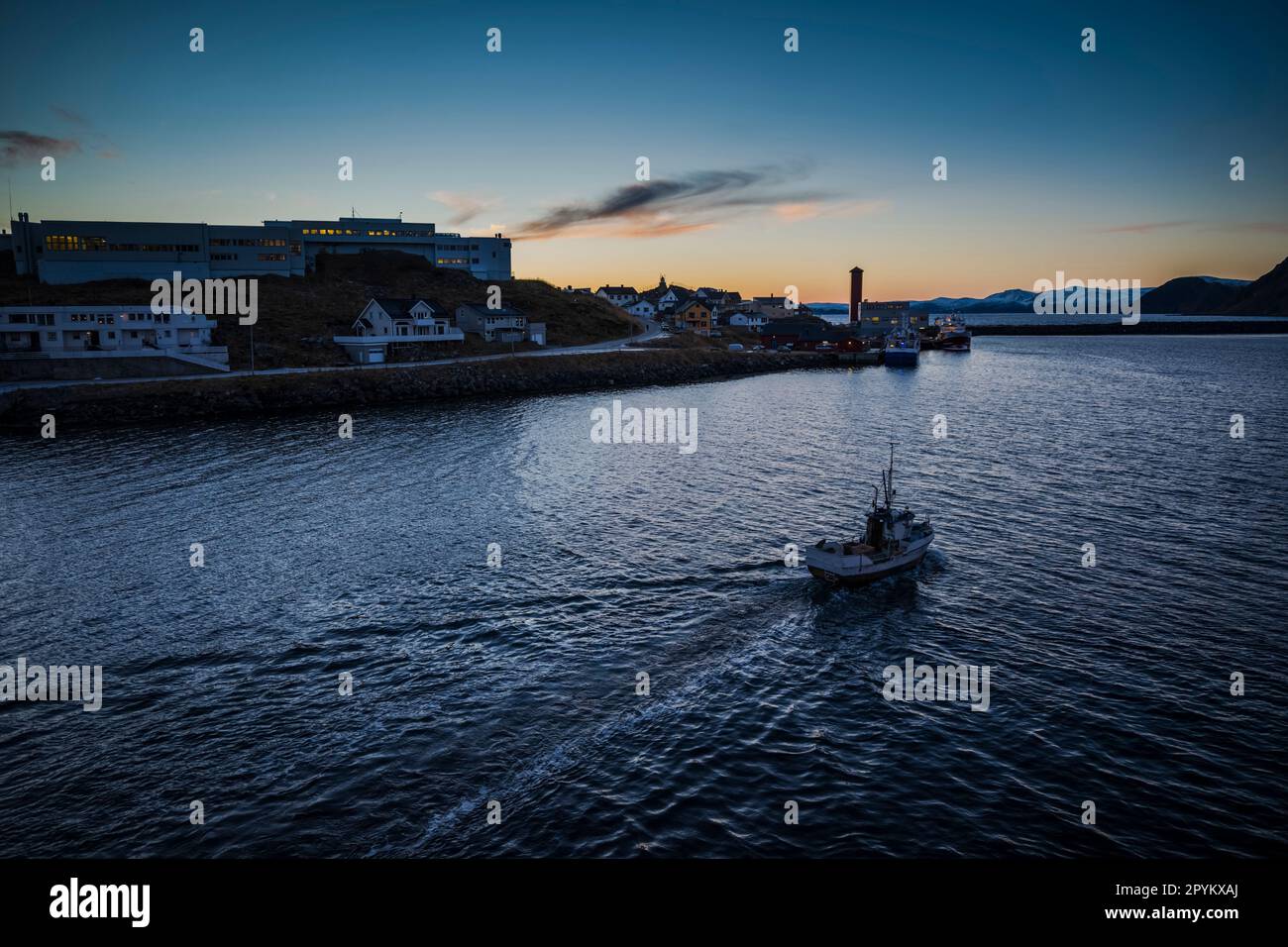 A small fishing boat heading out into the Norwegian Sea from Honinnsvag, Norway Stock Photo