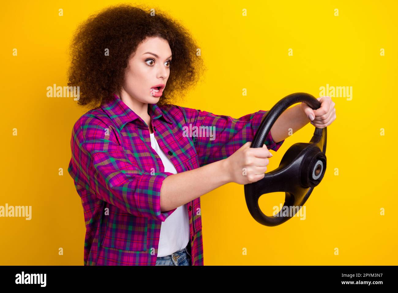 Photo of young nervous girl panic car accident funny driver hold steering wheel fast speed first time on road isolated over yellow color background Stock Photo