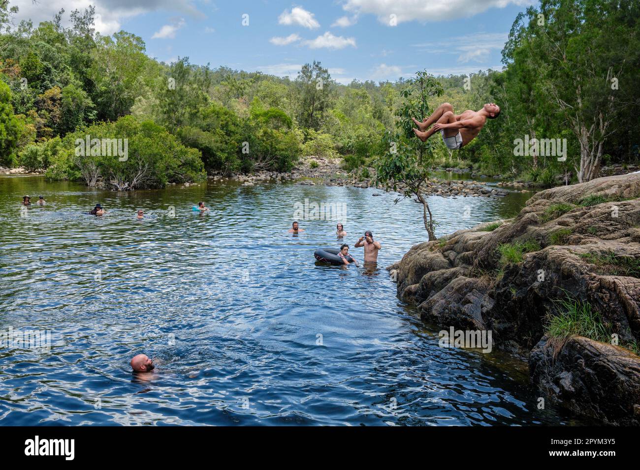A man does a somersault into Paradise Waterhole at Big Crystal Creek, Queensland, Australia Stock Photo