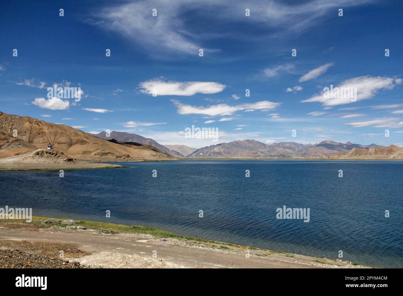 A beautiful serene landscape featuring a large body of water surrounded ...