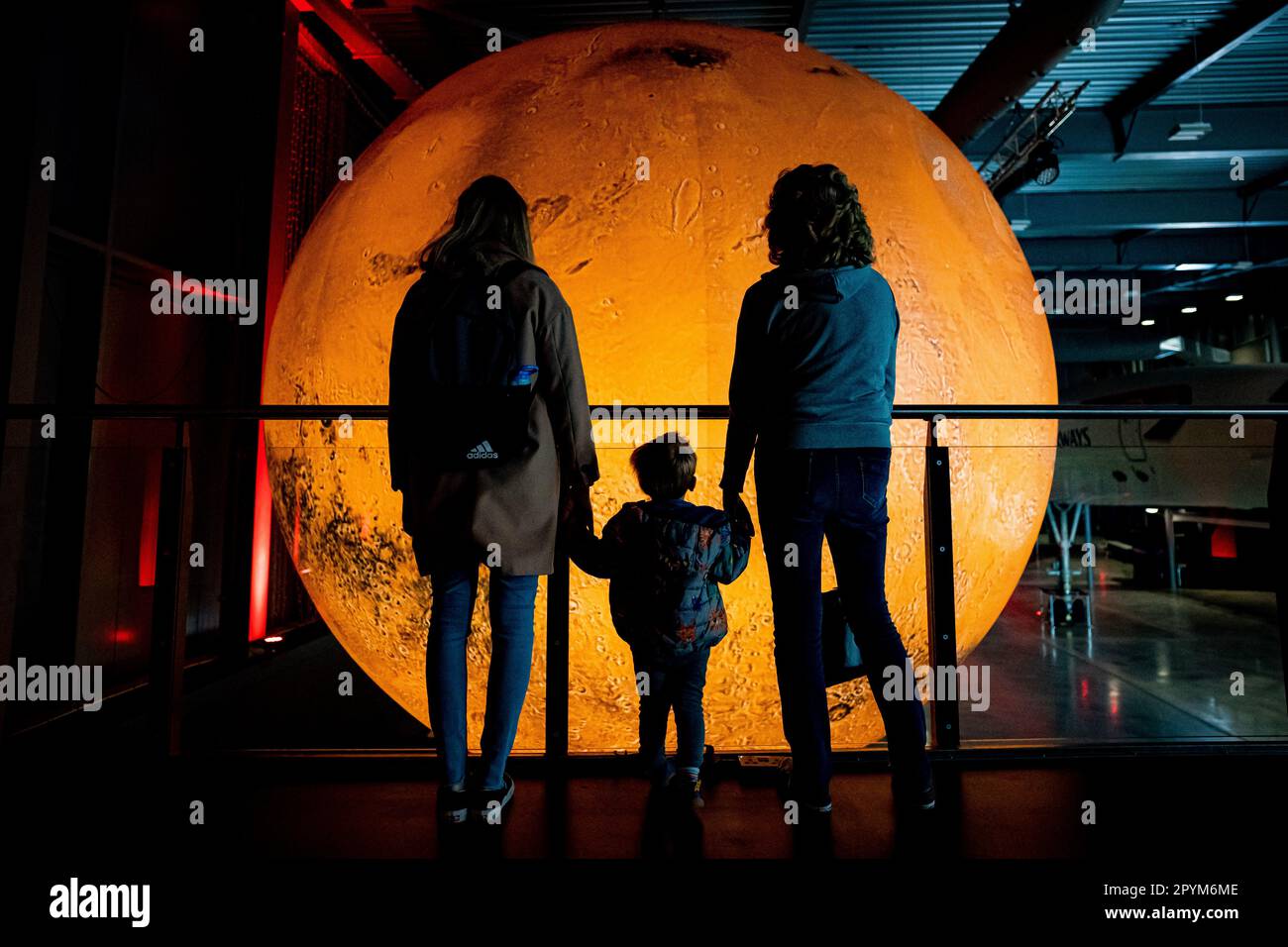 A family admire artist Luke Jerram's Mars installation at Aerospace Bristol, as part of a new Journey to Mars exhibition. The temporary exhibition marks the 20th anniversary of Mars Express, Europe's first mission to Mars, with models of the Mars Express Orbiter and the Beagle 2 lander on display alongside artist's Mars sculpture. Picture date: Thursday May 4, 2023. Stock Photo
