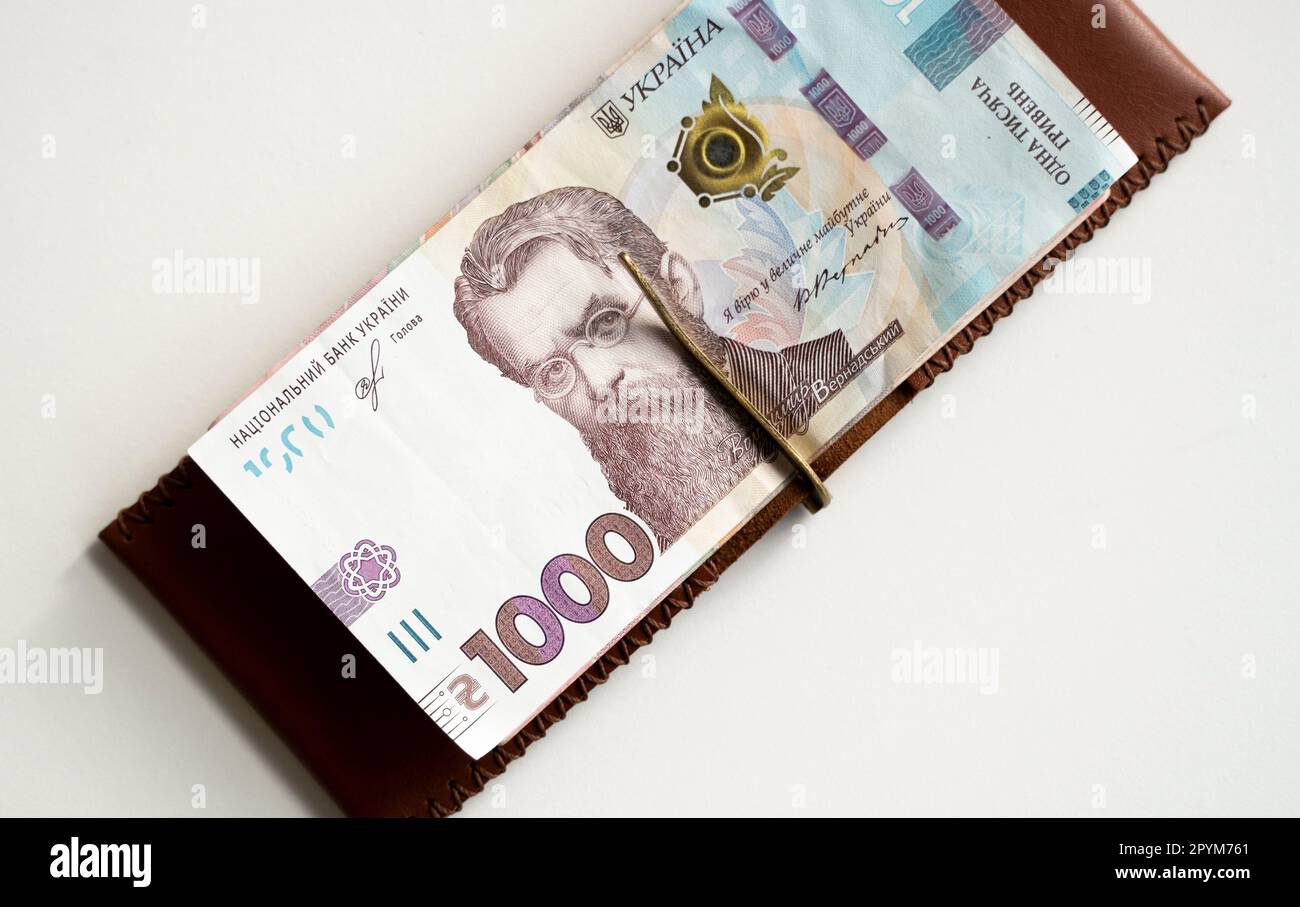 Brown leather money clip, purse with ukrainian hryvnia banknotes. Men's genuine leather wallet. Accessories. Money, financess, economy, saving. Stock Photo