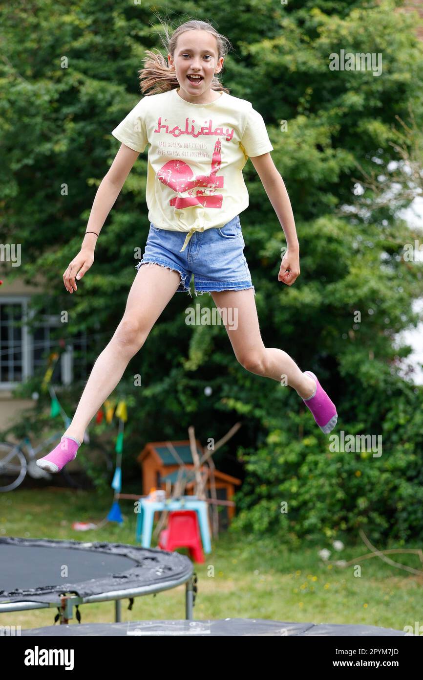 Young girl jumoing on a trampoline, Little Waltham, Essex, England Stock Photo