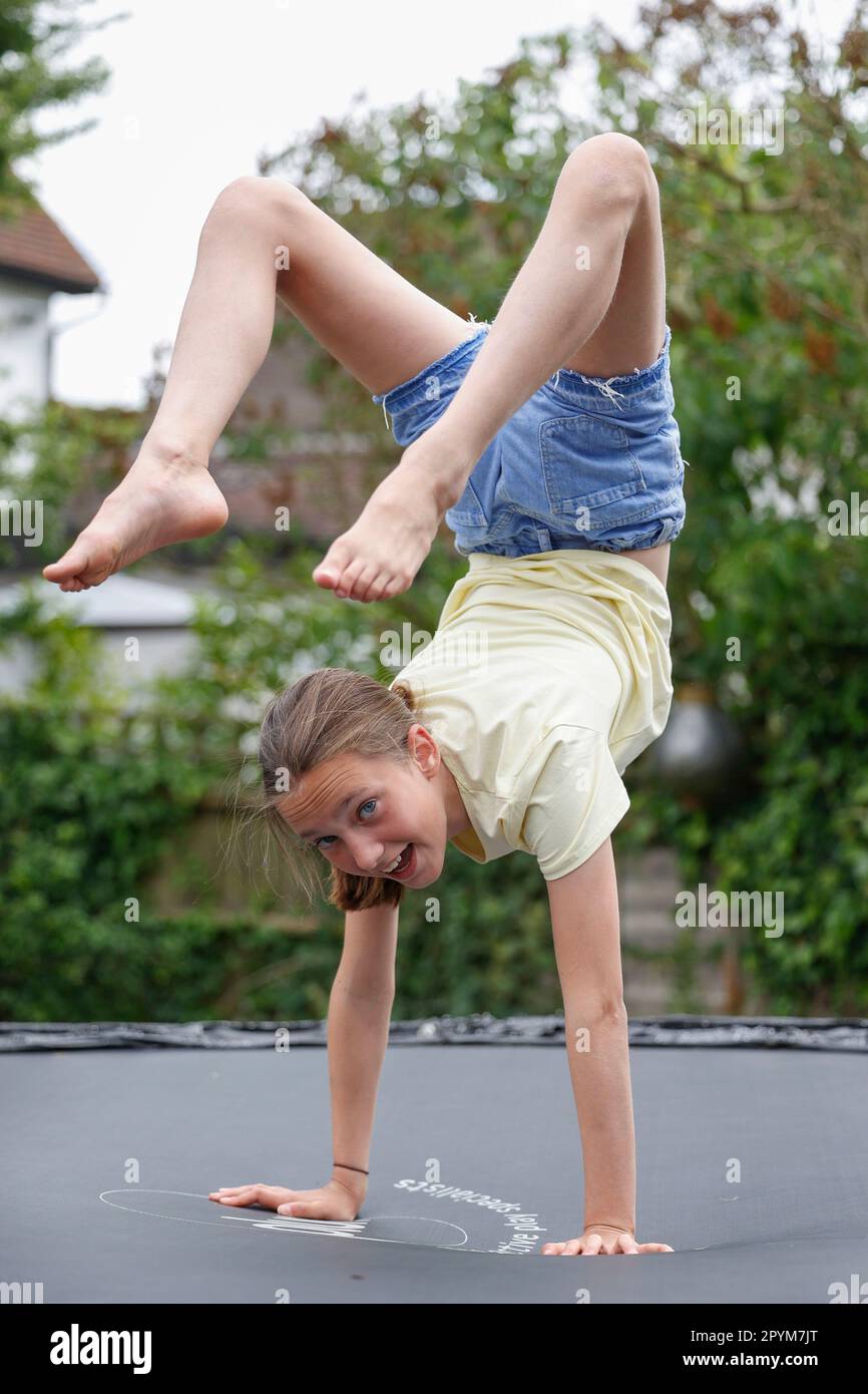 Young girl playing on a trampoline, Little Waltham, Essex, England Stock Photo