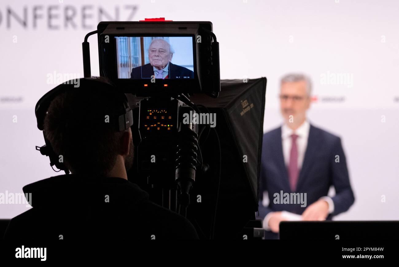 04 May 2023, Baden-Württemberg, Künzelsau: Reinhold Würth can be seen in a playback on a monitor while Robert Friedmann (r), Chairman of the Central Managing Board of the Würth Group, stands on the podium at the annual press conference. At the press conference, the Würth Group presented its annual financial statements and gave an outlook on the current fiscal year. Photo: Marijan Murat/dpa Stock Photo