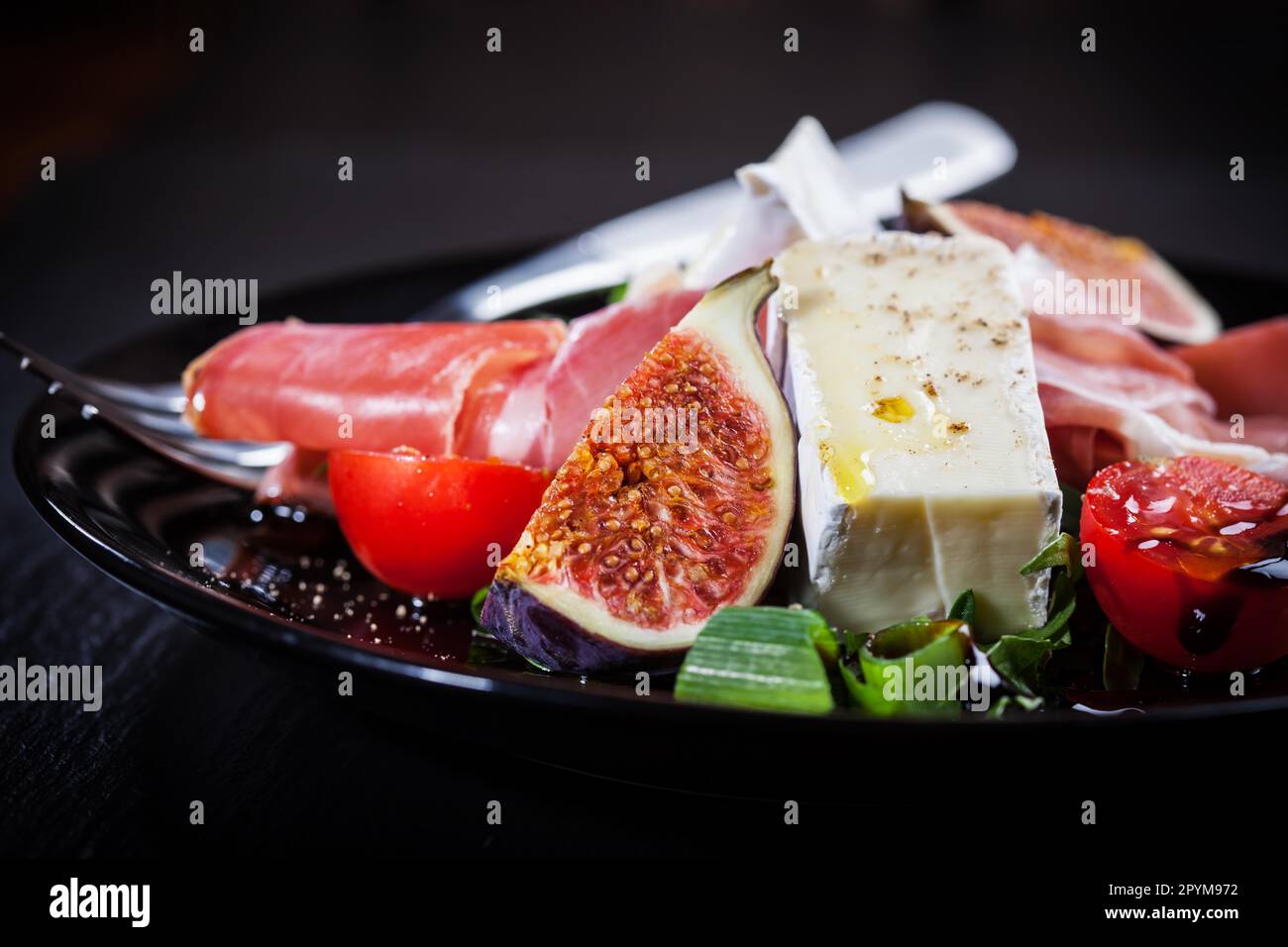 Antipasti plate with fresh figs, cheese and prosciutto Stock Photo