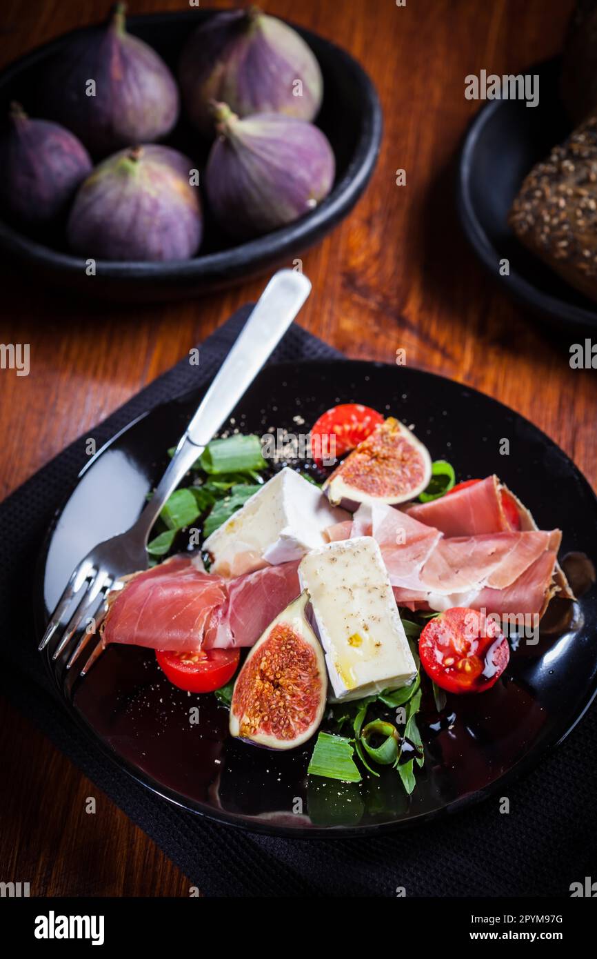Salad with fresh figs, cheese, prosciutto and cheese Stock Photo