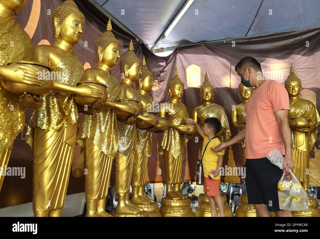 Kuala Lumpur, Malaysia. 04th May, 2023. A young devotee drops a coin at
