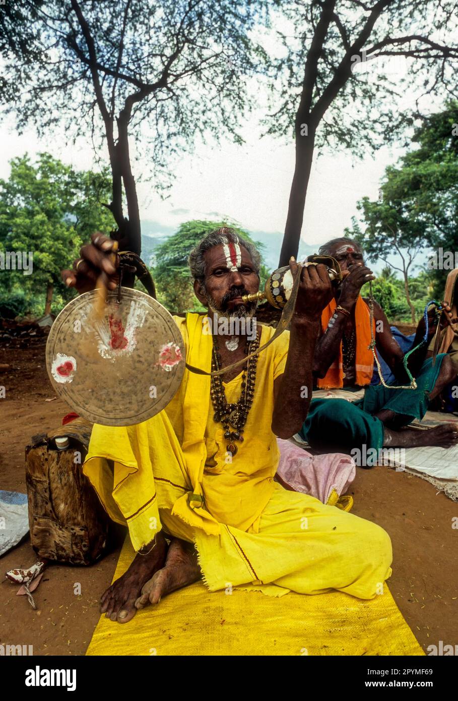 A Sadhu beating and blowing a conch shell at Nellithurai near Mettupalayam, Tamil Nadu, South India, India, Asia Stock Photo