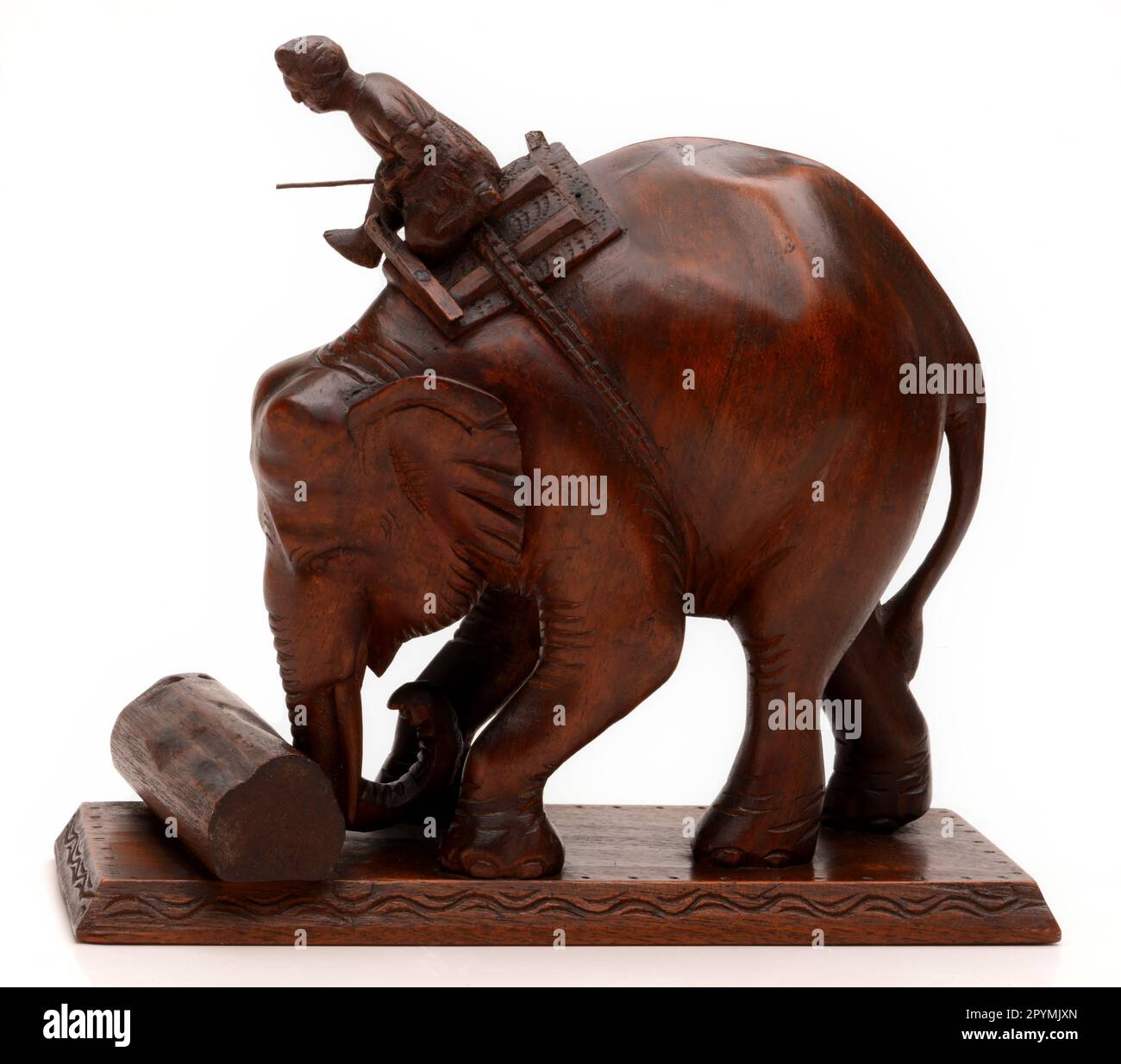 Elephant from Myamar carved in Burmese Rosewood in the 1920's showing man and animal working together to move timber. (Ht. 25cms) Stock Photo