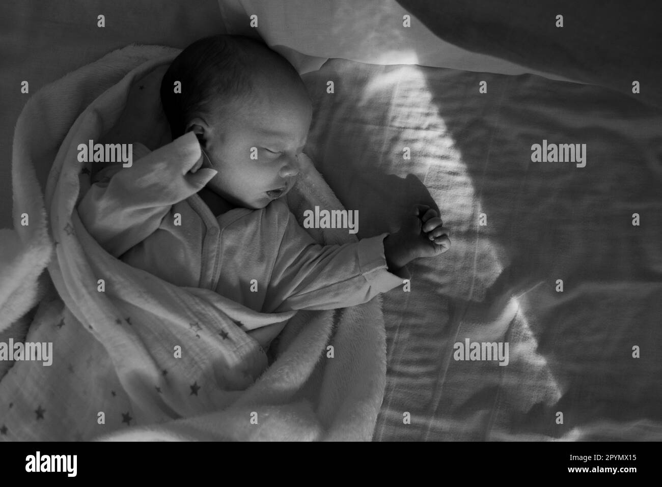 A newborn baby sleeping in her bed Stock Photo