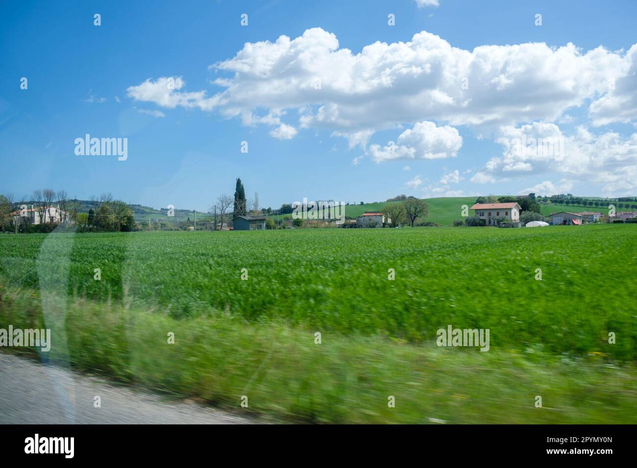 View of a rural Italian landscape through a car window as it passes by ...