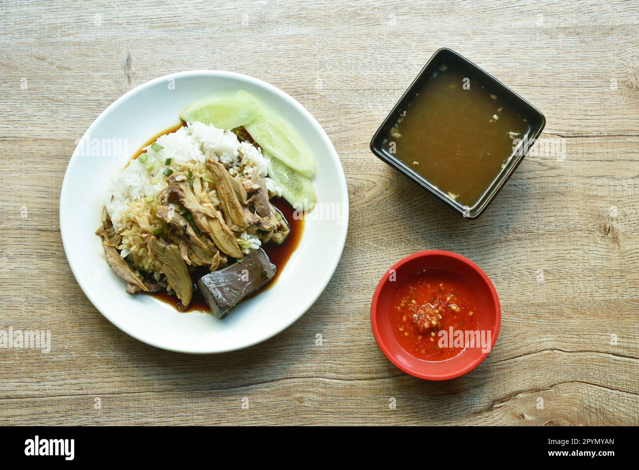 boiled duck meat and blood in brown Chinese herb soup topping on rice ...