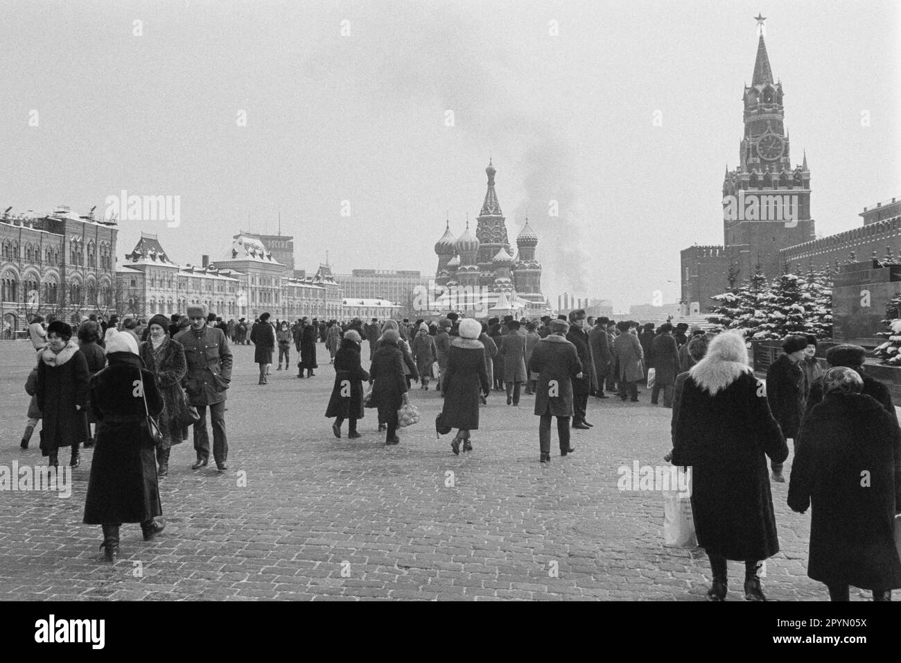 1985: People in Moscow's Red Square visiting Lenin’s mausoleum in front of St. Basil's Cathedral, the Kremlin and Spassky Tower. Stock Photo