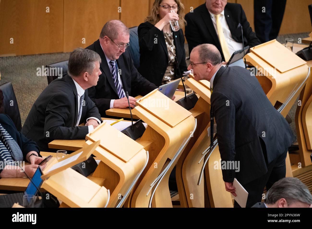 Edinburgh, Scotland, UK. 4th May, 2023. PICTURED: (L) Keith Brown MSP, Former Scottish Cabinet Minister for Justice speaking with (R) Jim Fairlie MSP for Perthshire South and Kinross-shire of the Scottish National Party, speaking to each other whilst the First Minister is standing up sneering a question. Scenes inside Holyrood showing the corridor and chamber views of the MSPs at the weekly session of First Ministers Questions (FMQs). Credit: Colin D Fisher/CDFIMAGES.COM Credit: Colin Fisher/Alamy Live News Stock Photo
