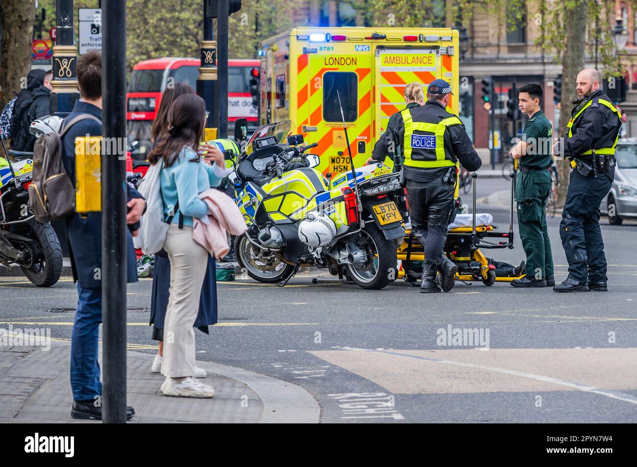 London, UK. 4th May, 2023. Emergency services including Ambulance Crews from the London Ambulance Service and motorcycle police attend an injured man on the road next to Trafalgar Square. The build up to the coronation means that central london is flooded with police and ambulances for security and safety. Credit: Guy Bell/Alamy Live News Stock Photo
