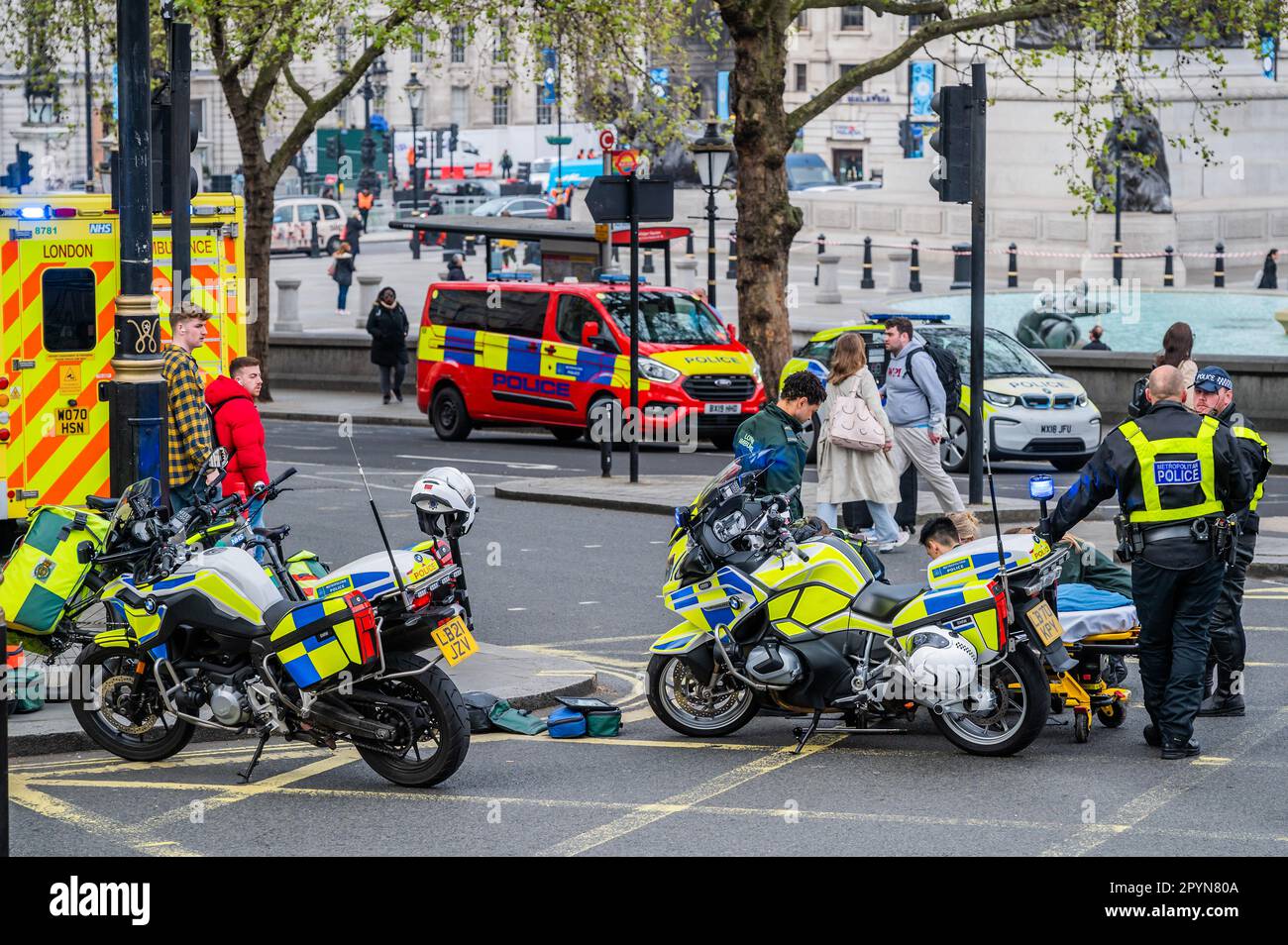 London, UK. 4th May, 2023. Emergency services including Ambulance Crews from the London Ambulance Service and motorcycle police attend an injured man on the road next to Trafalgar Square. The build up to the coronation means that central london is flooded with police and ambulances for security and safety. Credit: Guy Bell/Alamy Live News Stock Photo