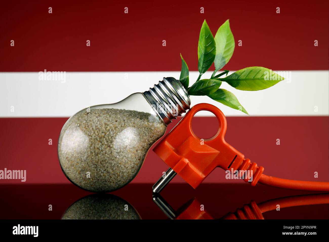 Plug, plant growing inside the light bulb and Latvia Flag. Green eco