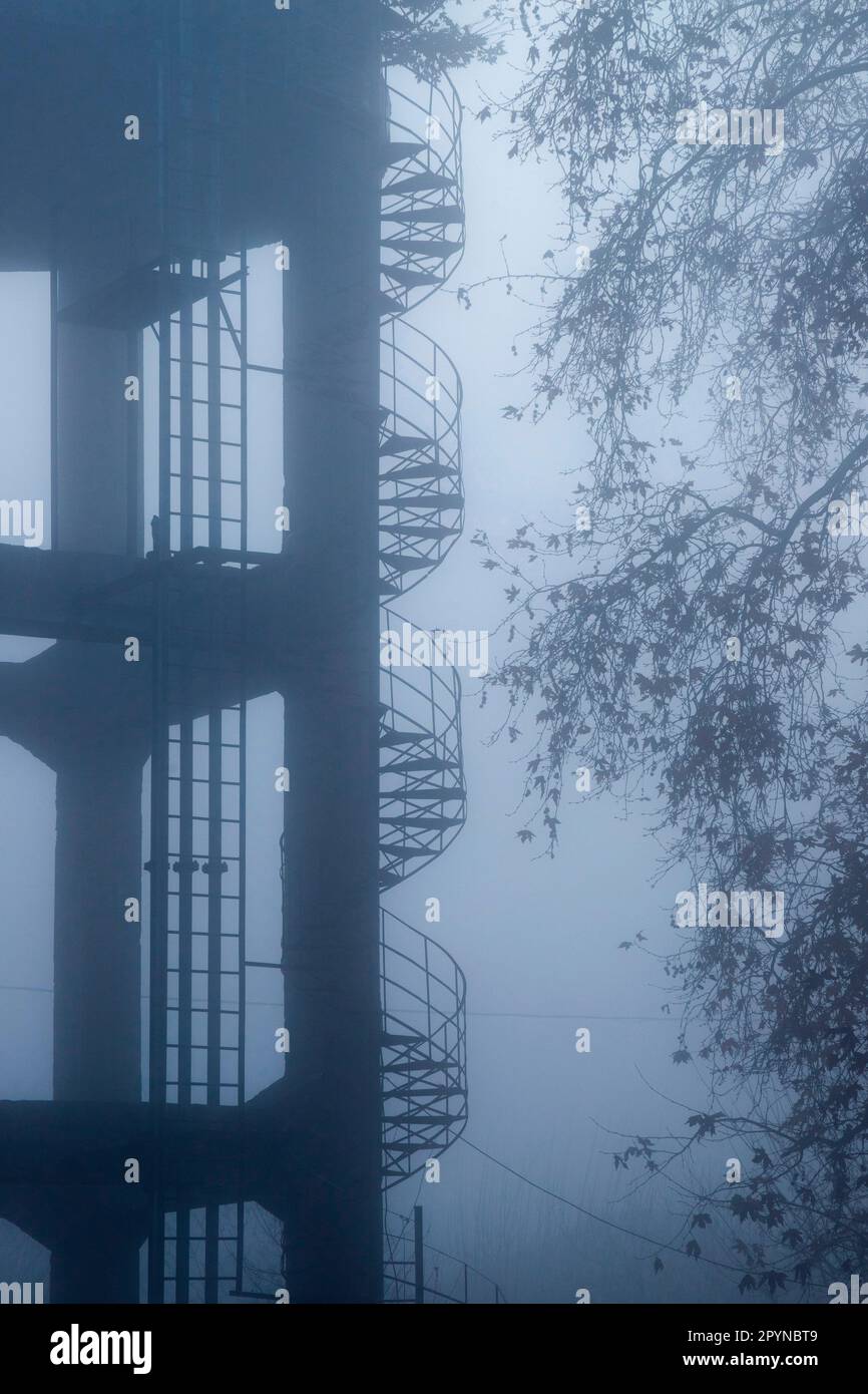 A watertower's staircase on a foggy day in Rodia village, municipality of Tirnavos, Larissa, Thessaly, Greece Stock Photo