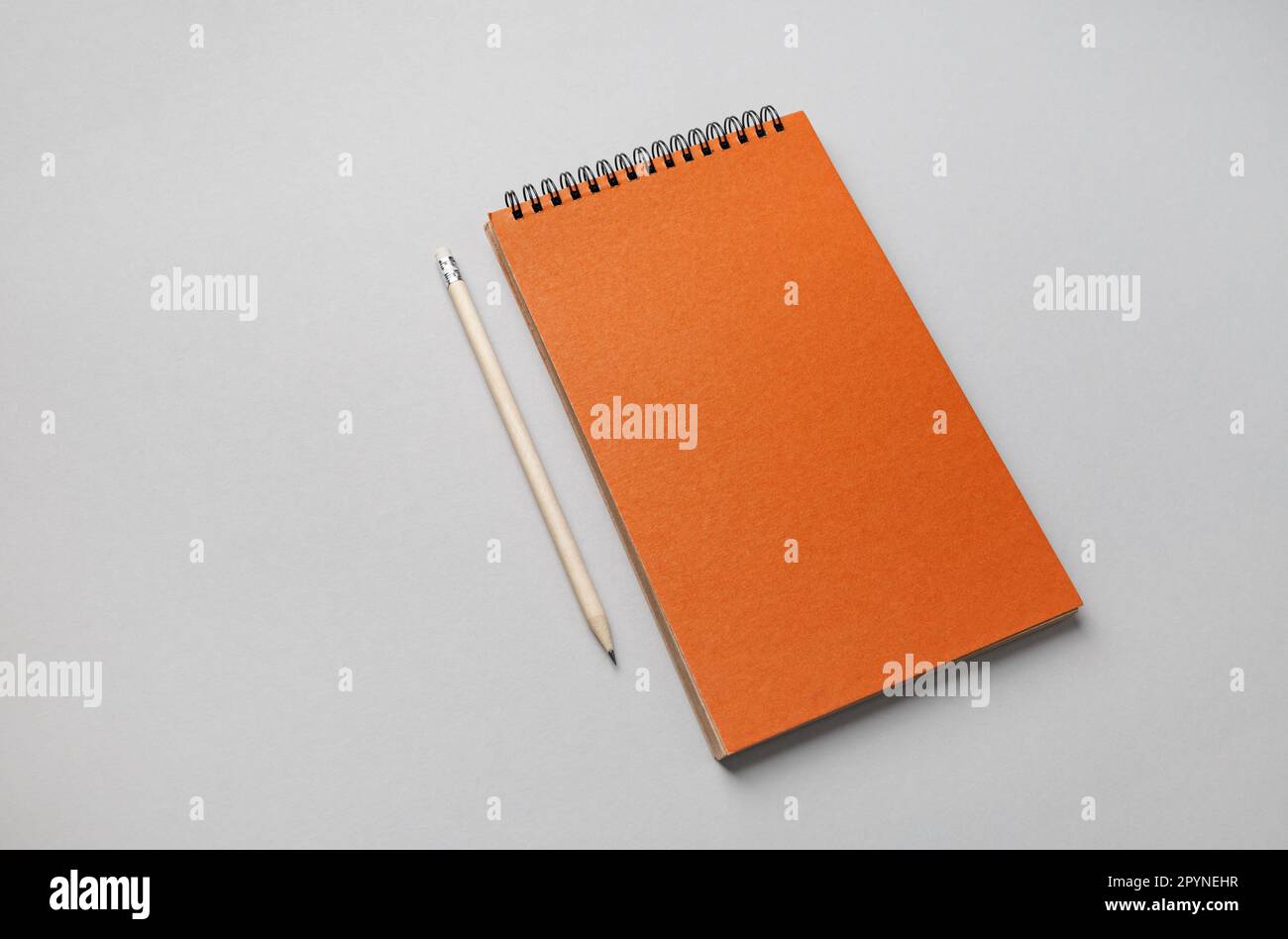 https://c8.alamy.com/comp/2PYNEHR/photo-of-blank-orange-sketchbook-and-pencil-on-gray-paper-background-2PYNEHR.jpg