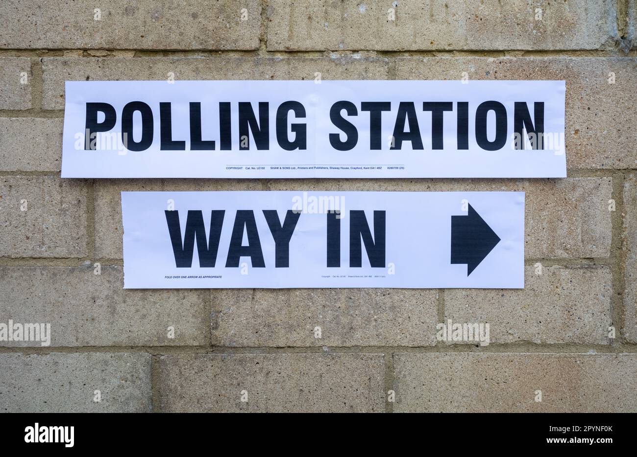 A sign reading 'Polling Station' with the words 'Way In' underneath fixed to a wall for elections in the UK.  With a controversial new law requiring p Stock Photo