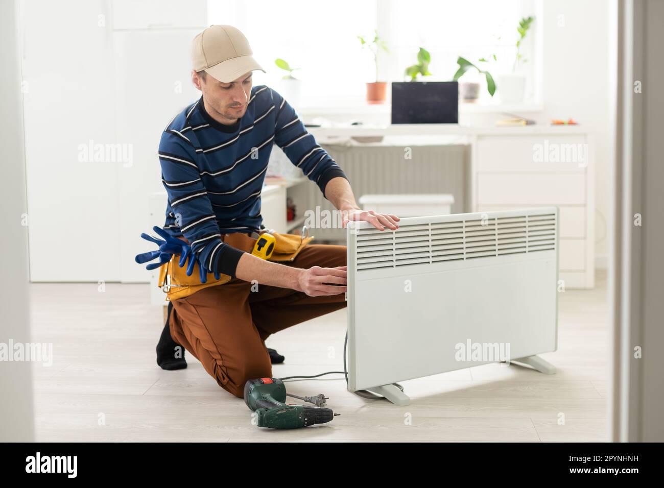 the master repairs the electric heater Stock Photo Alamy
