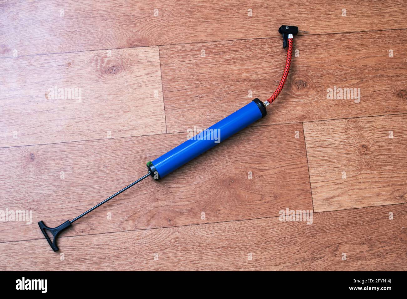 Bicycle wheel pump on wooden floor close up Stock Photo