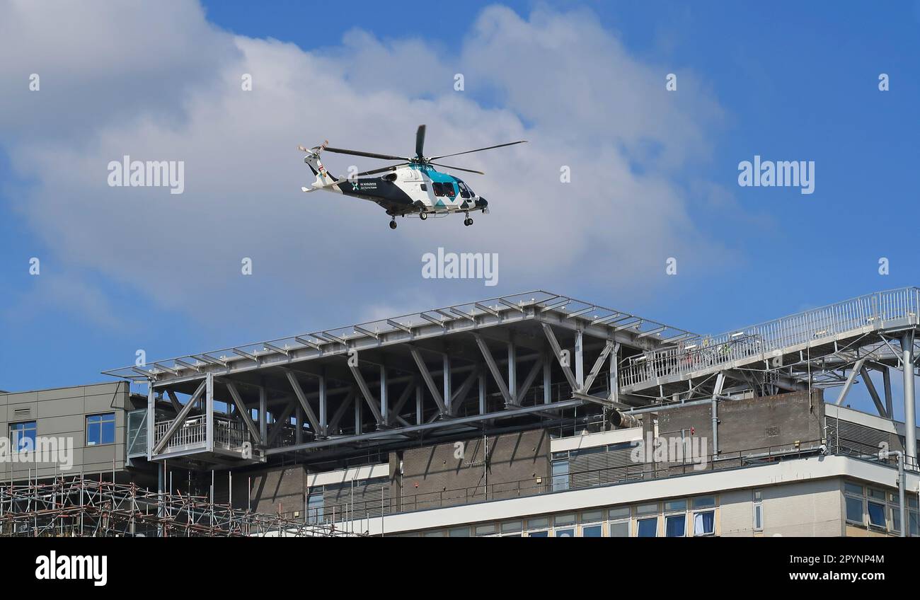 A East Surrey Air Ambulance helicopter lands on the rooftop helipad at Kings College Hospital in South London, UK. Stock Photo