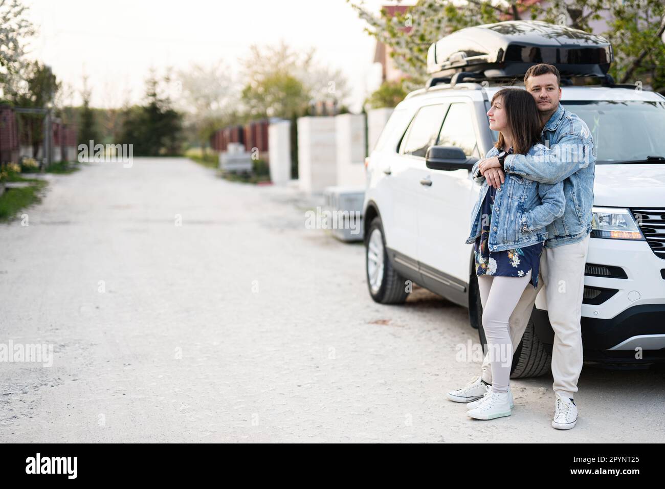 Stylish couple in jeans jacket standing near white american suv car ...