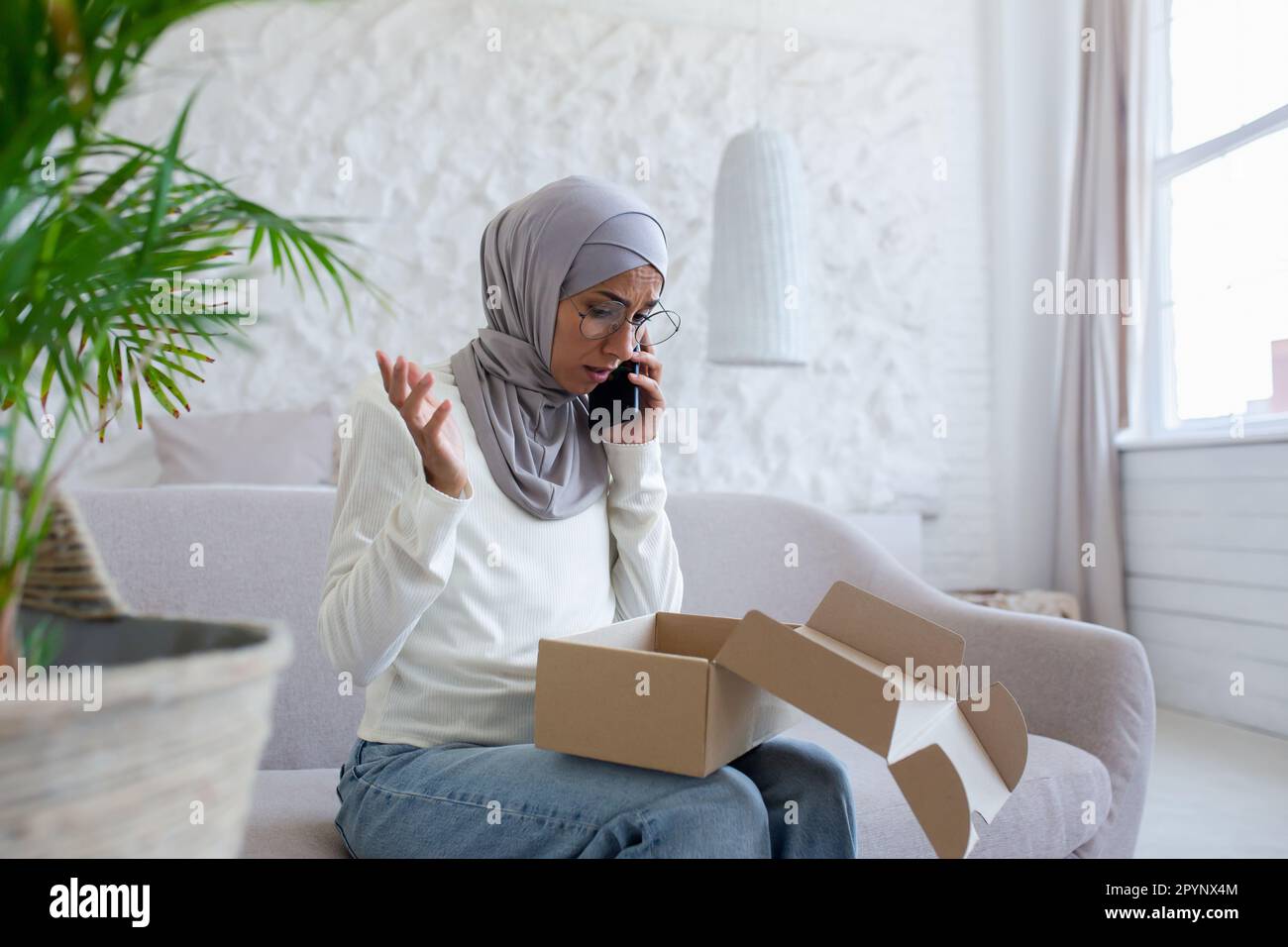 Problems with home delivery. Young muslim woman in hijab sitting on