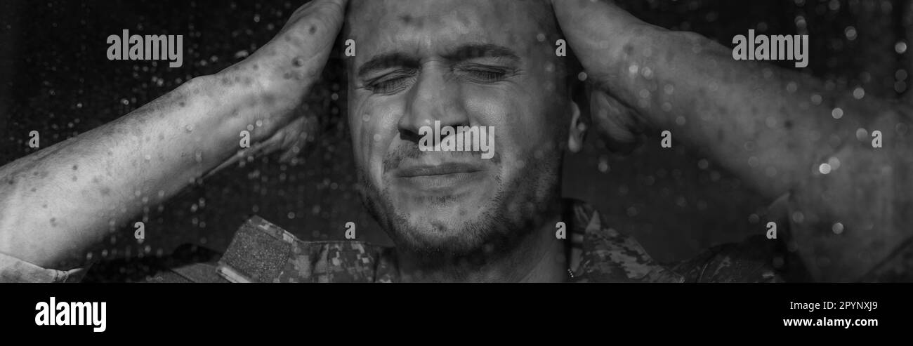black and white photo of anxious serviceman suffering from ptsd while standing next to window with raindrops, banner,stock image Stock Photo