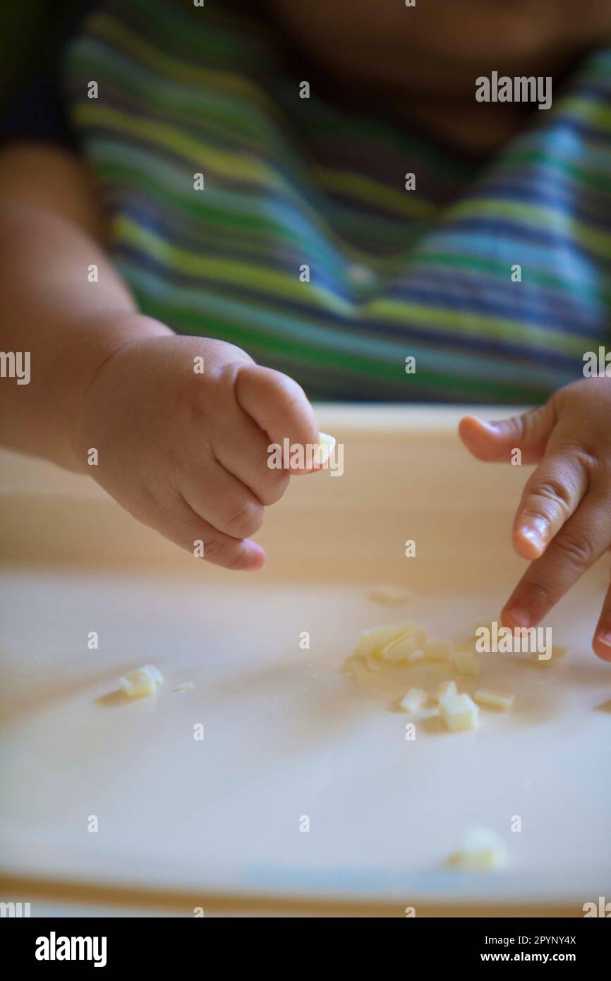 Baby using pincer grasp to pick up food, developmental milestones, ages