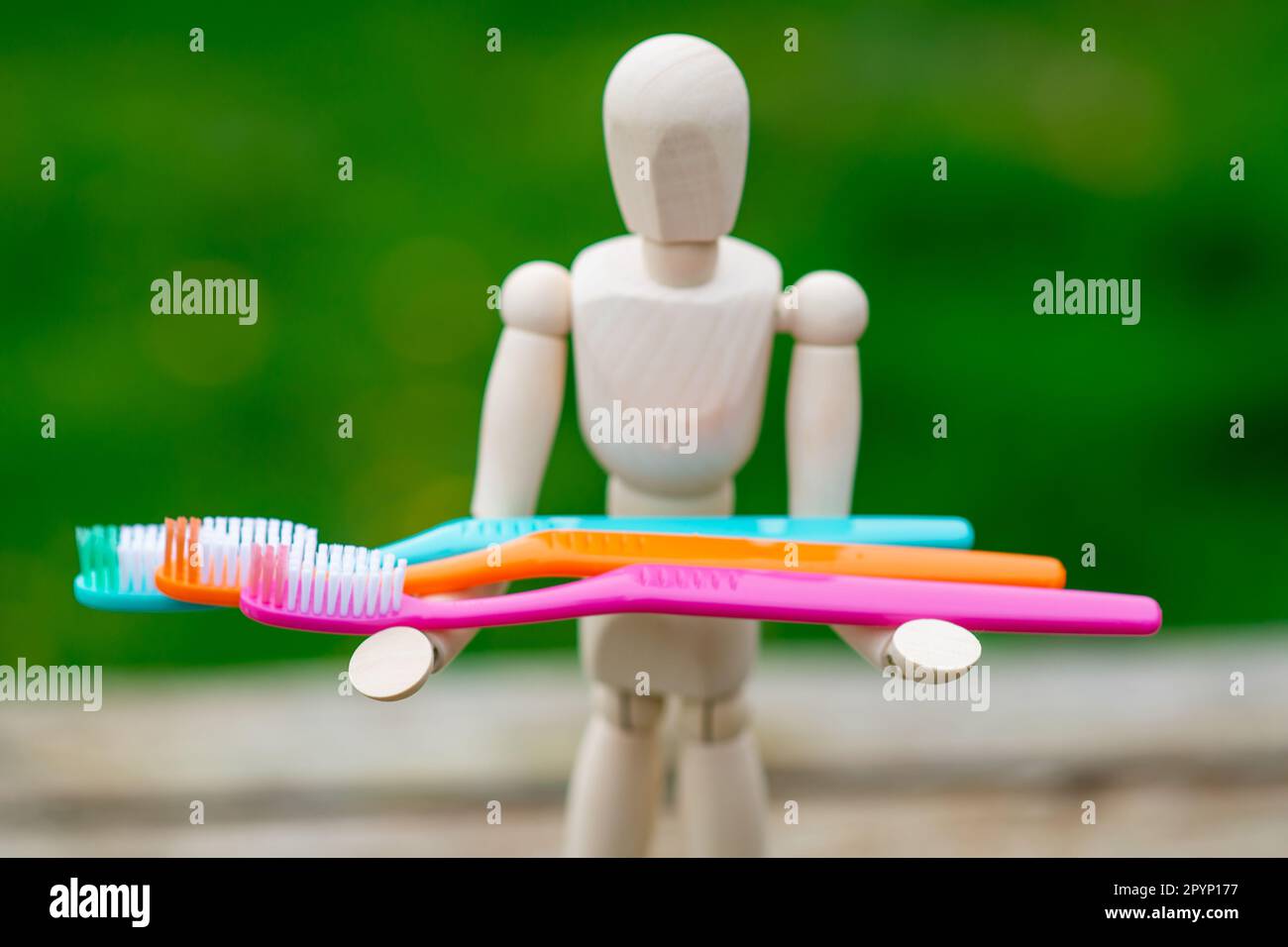 brush your teeth concept. The figure of a man holds multicolored