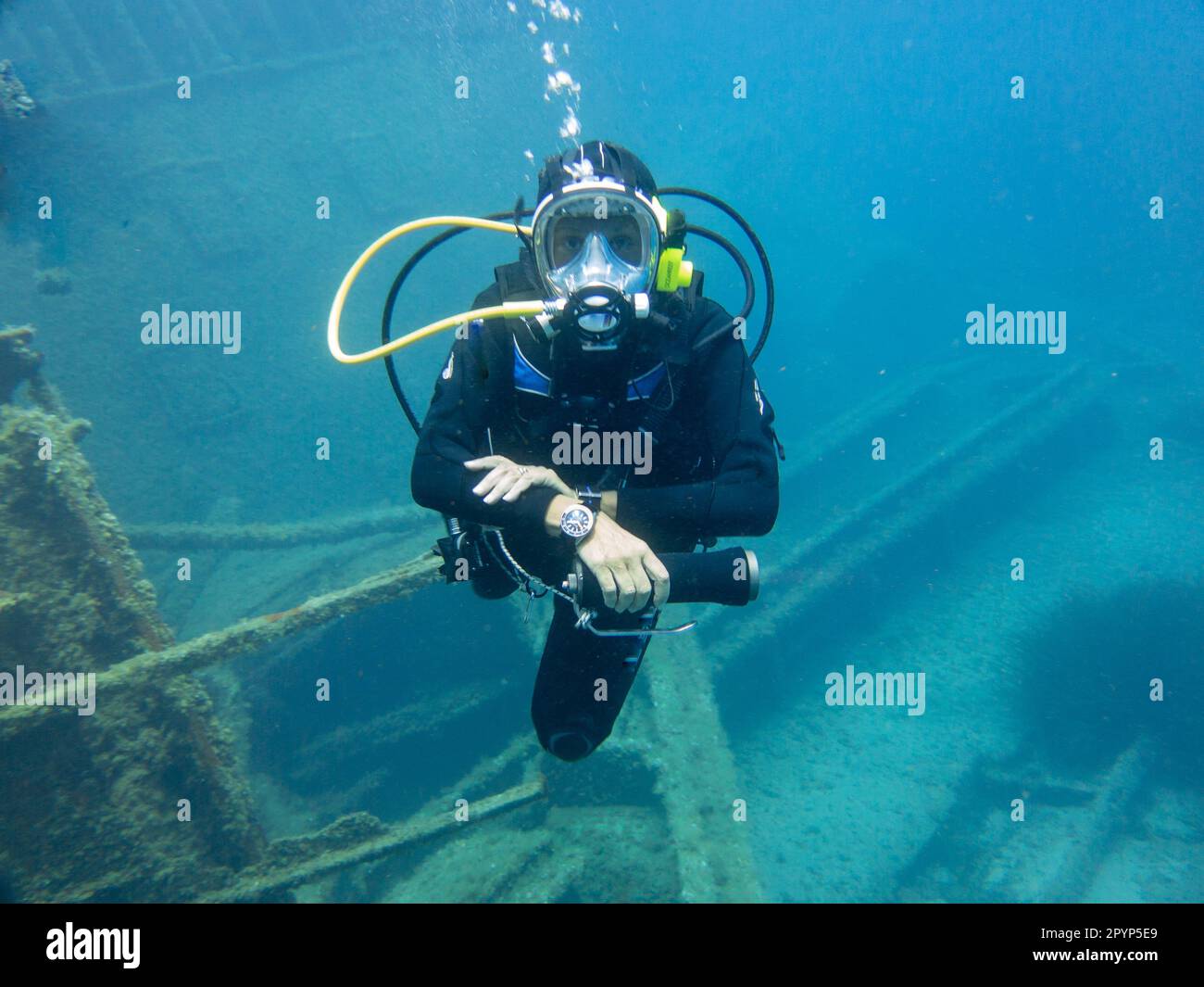 Scuba Diver with full face mask looking at the camera on a shipwreck Stock Photo