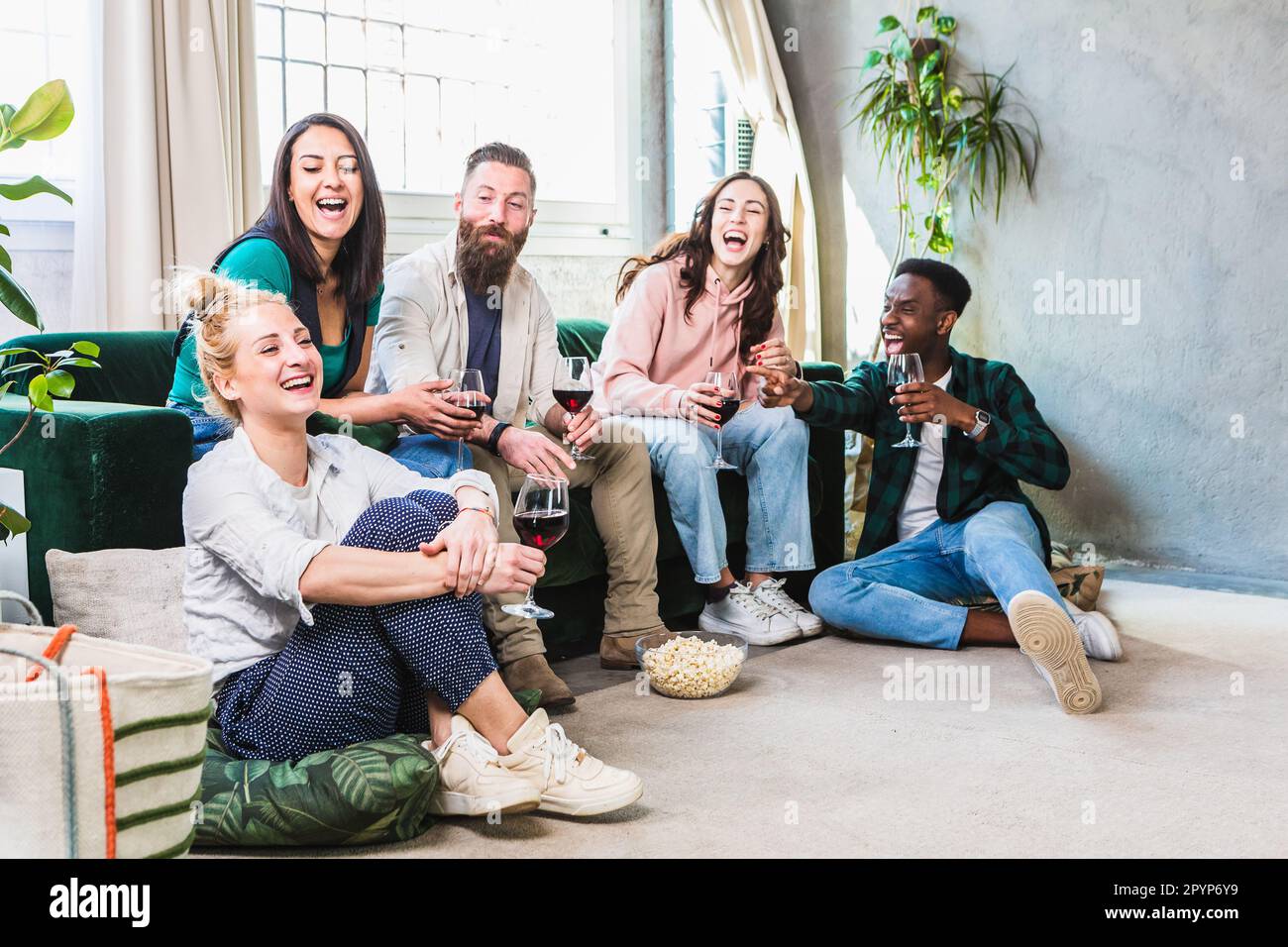 Playful scene of friends at home laughing and joking with each other. Fun evening among young boys. Multiethnic group indoors Stock Photo