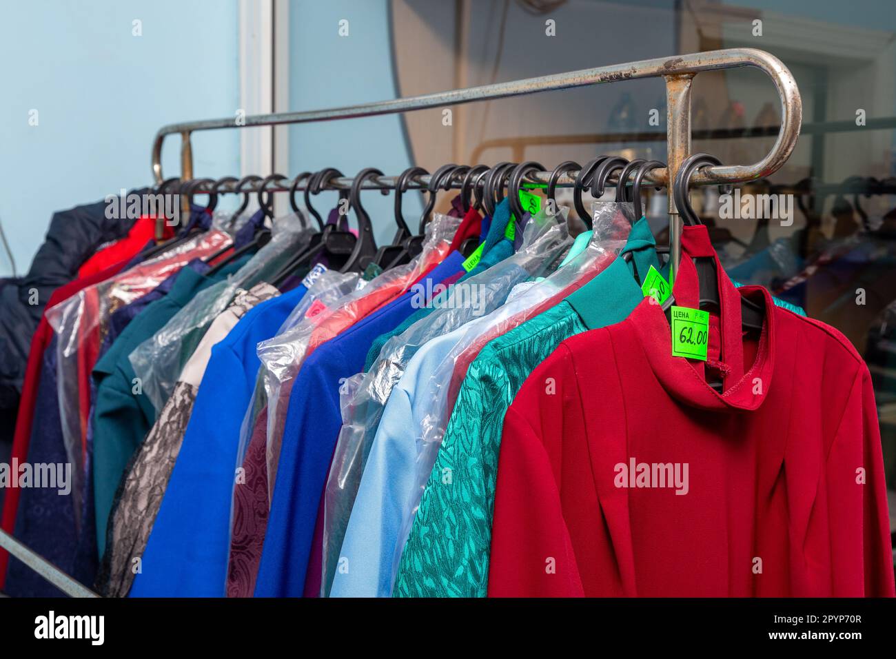 Hangers with men suits and women clothes for the deceased in a funeral
